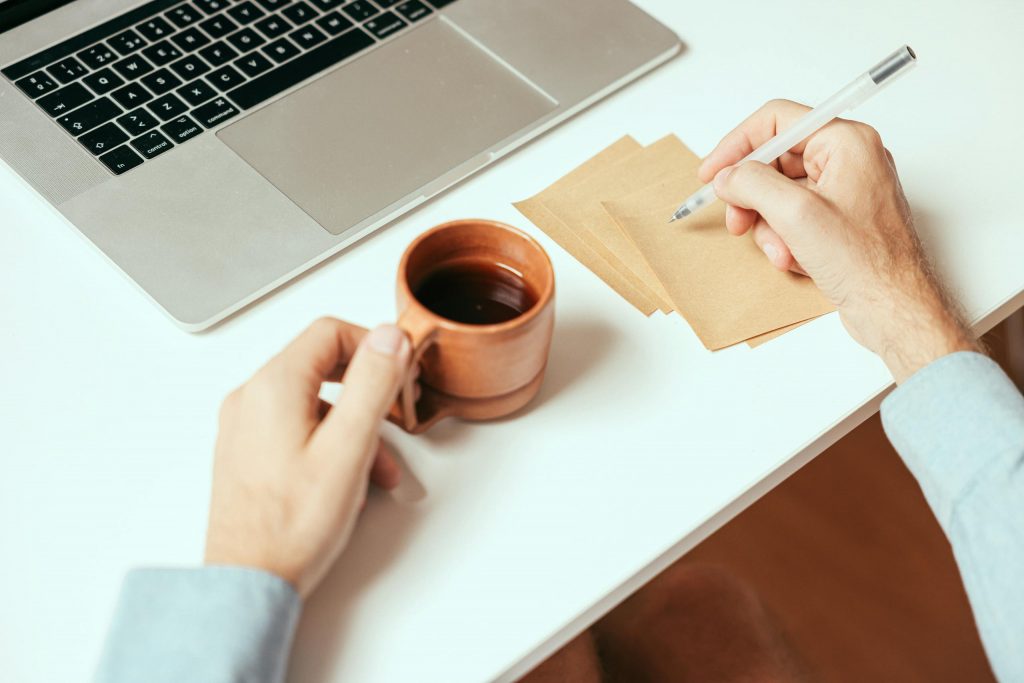 Eine Person schreibt auf einen Post-it-Zettel. Dies ist die Einleitung zu einem Artikel über meinen Markenstrategie-Prozess